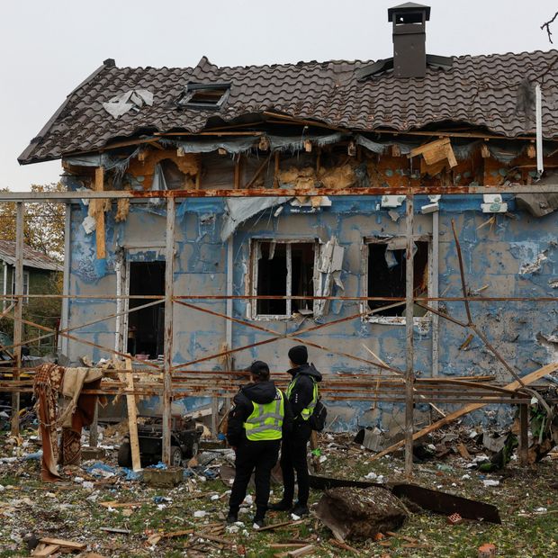Policías observan una casa dañada en Kiev