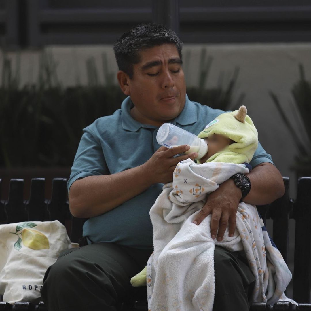 Un señor alimenta a un bebé