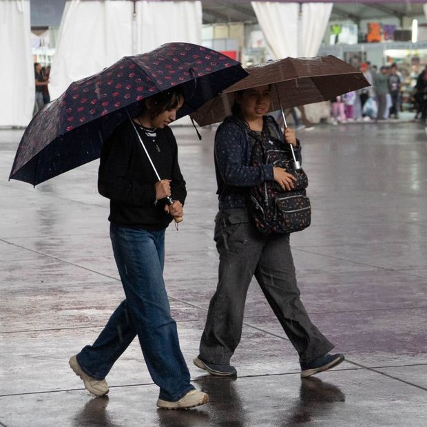 Dos mujeres caminan durante una tarde lluviosa en la zona centro de la CDMX