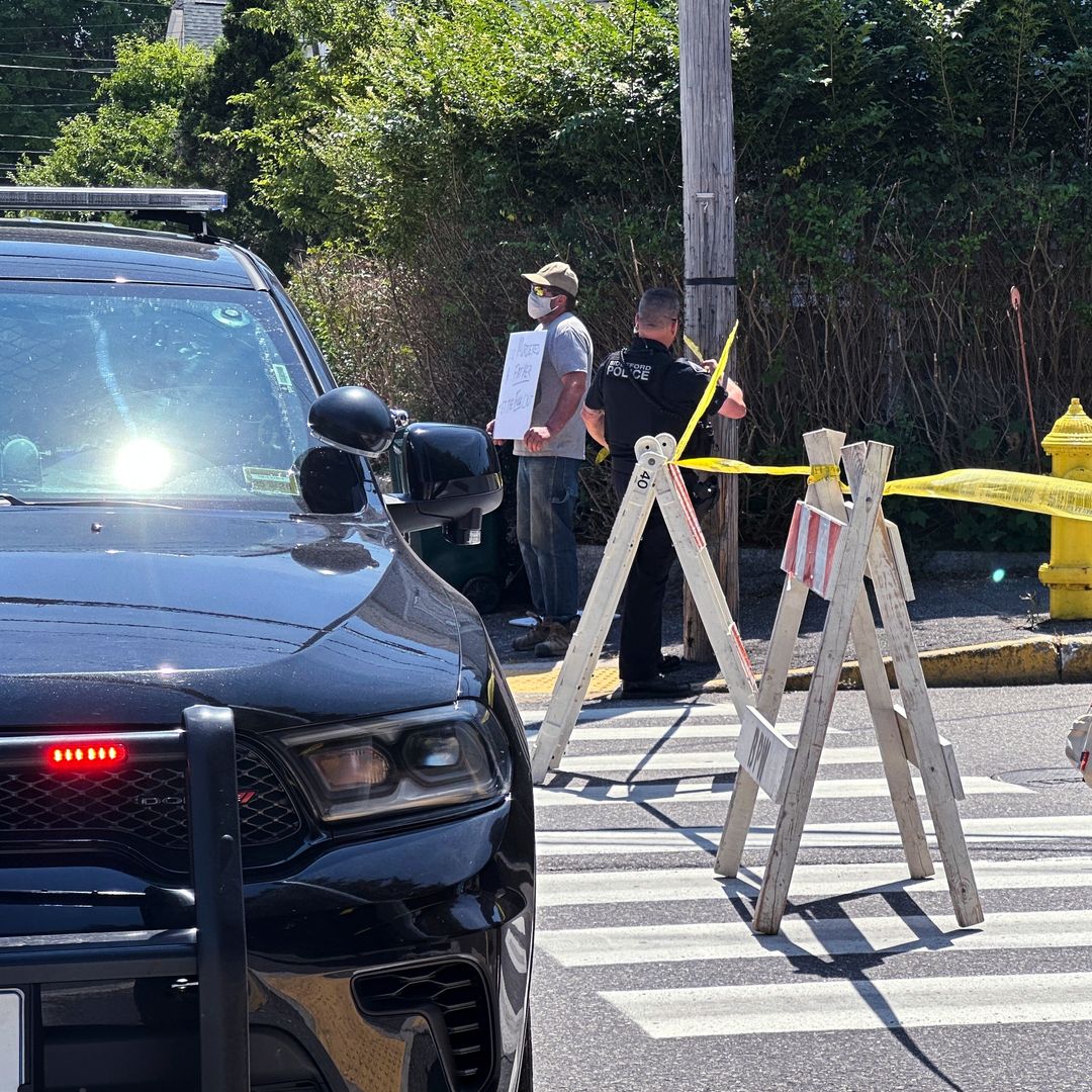 Personas observan el operativo mientras autoridades mantienen cerrada una carretera tras un tiroteo relacionado con agentes del ICE en Biddeford, Maine.