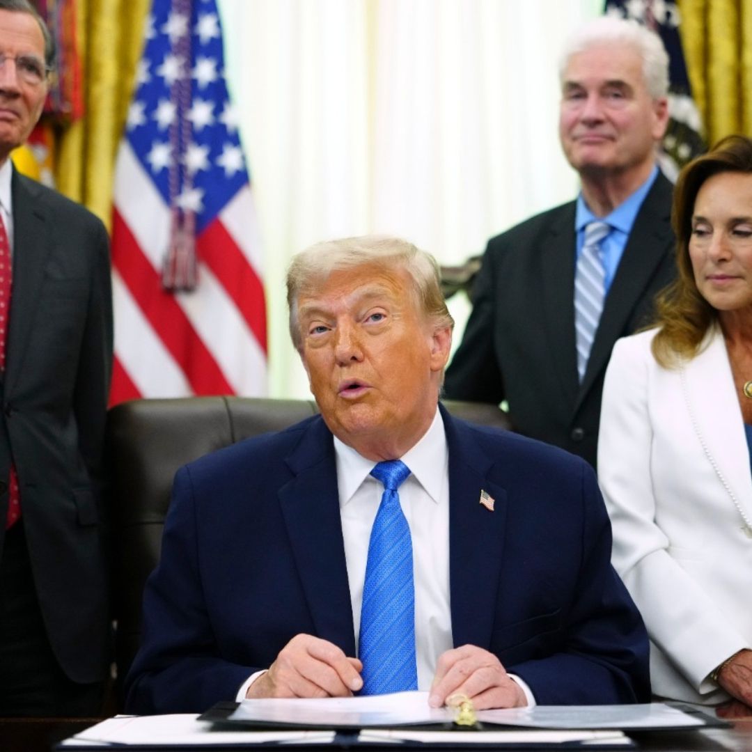 El presidente de Estados Unidos, Donald Trump, muestra la Ley de Seguridad Estadounidense tras firmarla en el Despacho Oval de la Casa Blanca