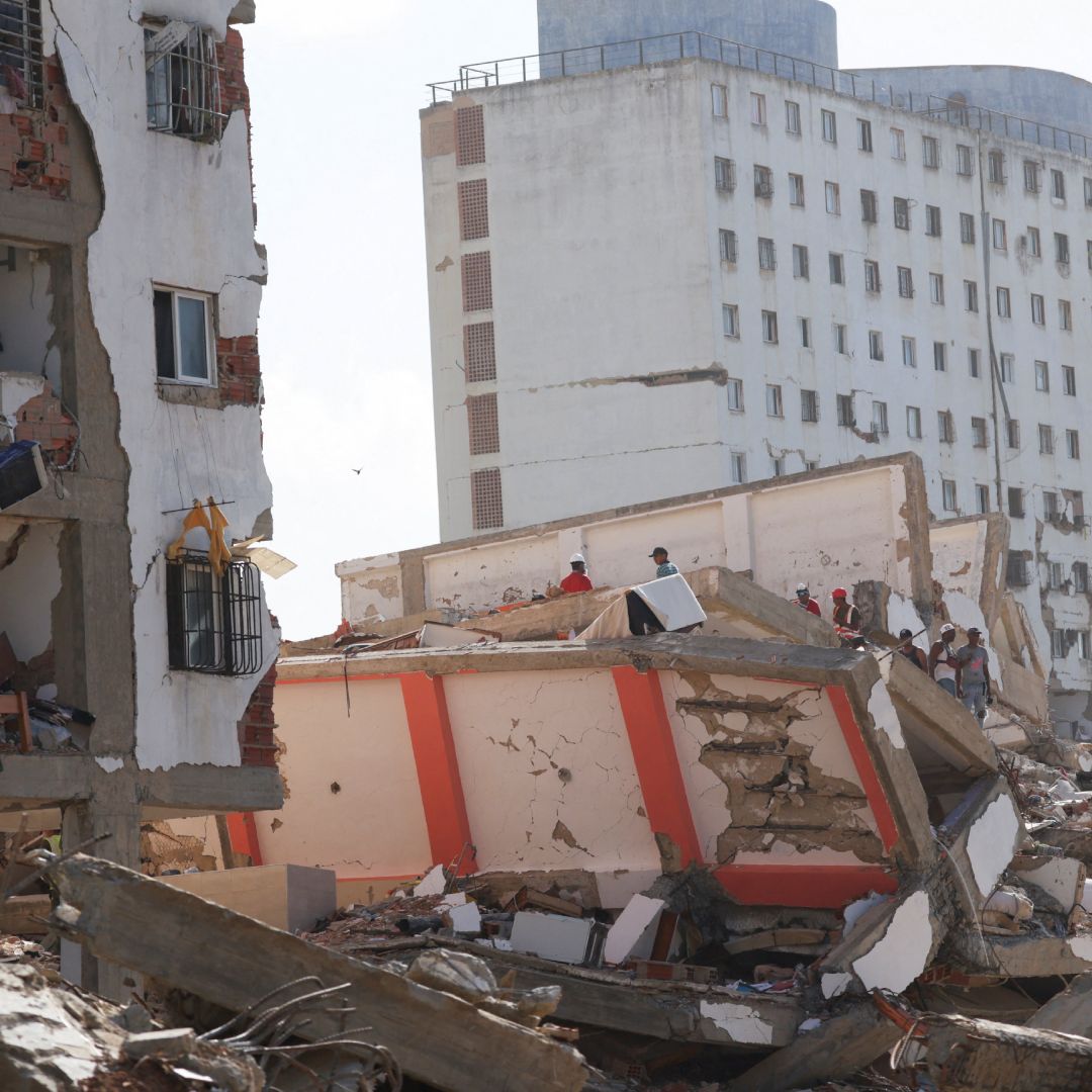 Personas buscan entre los escombros tras los terremotos del 24 de junio en La Guaira.