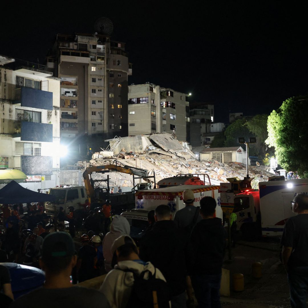 Servicios de emergencia laboran en el lugar de un edificio colapsado tras los terremotos en Venezuela.